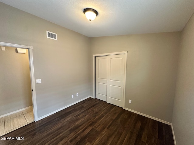 7217 Long Meadow Dr, El Paso, TX 79934 - unfurnished bedroom featuring dark wood-style flooring, baseboards, and a closet