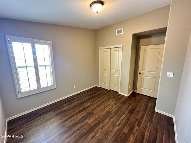 7217 Long Meadow Dr, El Paso, TX 79934 - unfurnished bedroom with dark wood finished floors, a closet, and baseboards