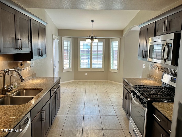 7217 Long Meadow Dr, El Paso, TX 79934 - kitchen featuring stainless steel appliances, a sink, decorative backsplash, baseboards, and dark stone counters