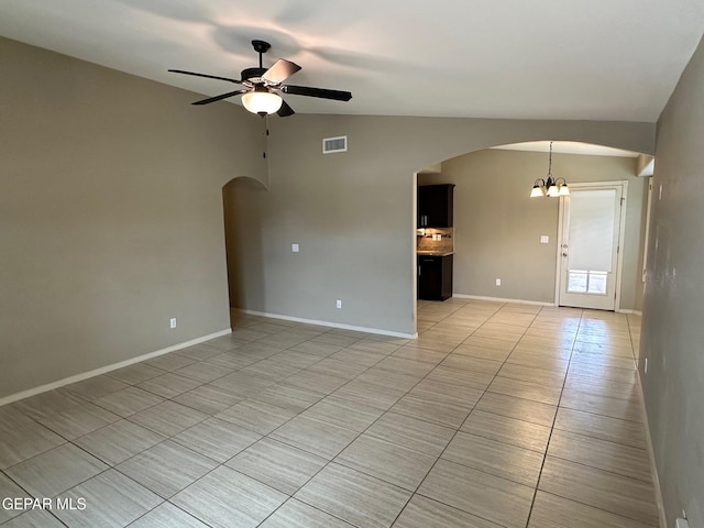 7217 Long Meadow Dr, El Paso, TX 79934 - empty room with light tile patterned floors, vaulted ceiling, ceiling fan, arched walkways, and a chandelier