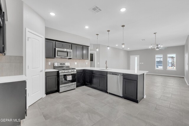 12169 Sanna Dr, El Paso, TX 79934 - kitchen featuring appliances with stainless steel finishes, a sink, backsplash, a peninsula, and light countertops