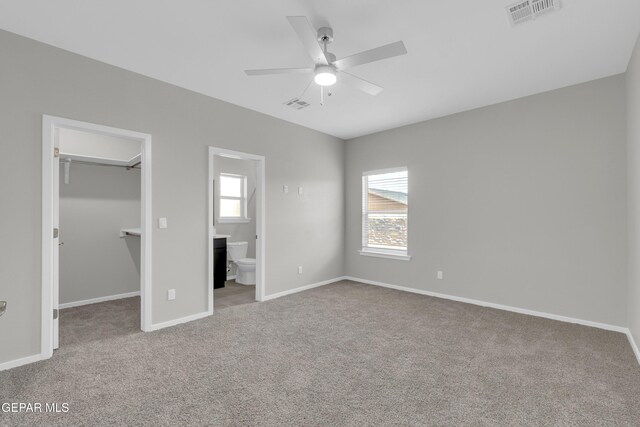 12169 Sanna Dr, El Paso, TX 79934 - unfurnished bedroom featuring a spacious closet, carpet floors, connected bathroom, and baseboards
