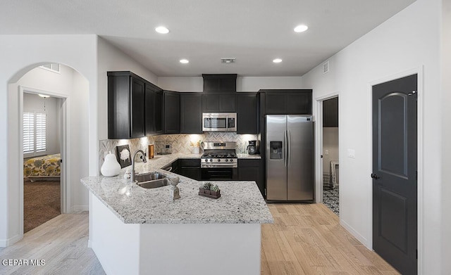 3809 Plan Pl, El Paso, TX 79938 - kitchen with stainless steel appliances, a sink, dark cabinets, light stone counters, and recessed lighting