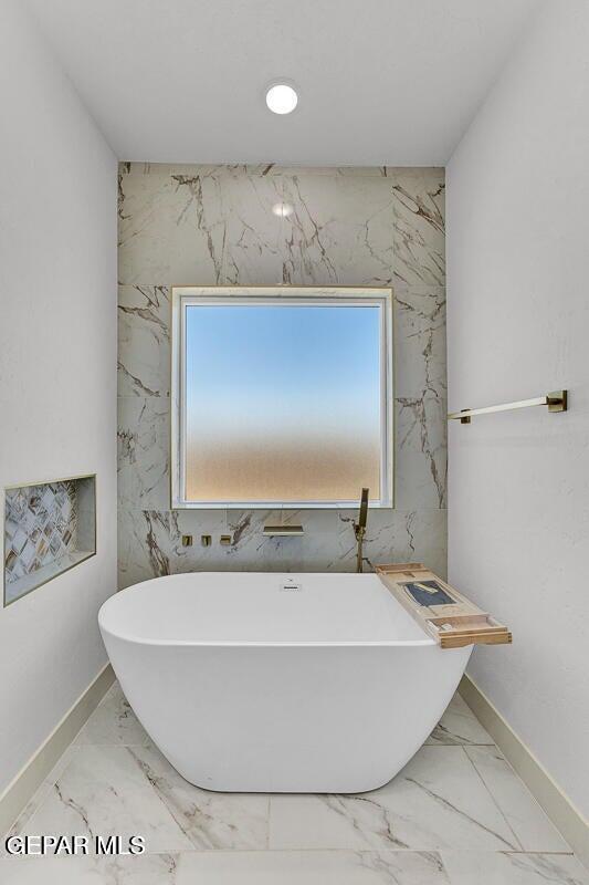 12748 Polo Norte Dr, El Paso, TX 79934 - bathroom with marble finish flooring, a freestanding tub, and healthy amount of natural light