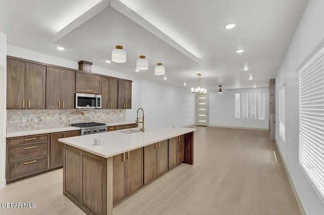 12748 Polo Norte Dr, El Paso, TX 79934 - kitchen with stainless steel microwave, decorative backsplash, light countertops, light wood finished floors, and recessed lighting