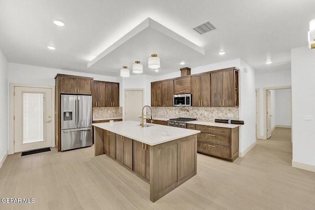 12748 Polo Norte Dr, El Paso, TX 79934 - kitchen featuring appliances with stainless steel finishes, backsplash, light countertops, a center island with sink, and recessed lighting