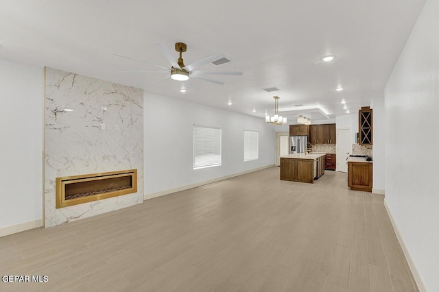 12748 Polo Norte Dr, El Paso, TX 79934 - unfurnished living room with a chandelier, a premium fireplace, recessed lighting, a ceiling fan, and light wood finished floors