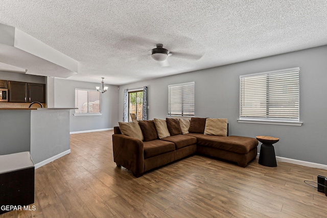 11912 Mesquite Miel Dr, El Paso, TX 79938 - living area featuring a chandelier, baseboards, wood finished floors, a ceiling fan, and a textured ceiling