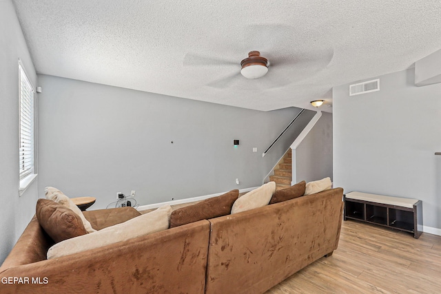 11912 Mesquite Miel Dr, El Paso, TX 79938 - living area with stairs, light wood-style flooring, a textured ceiling, a ceiling fan, and baseboards
