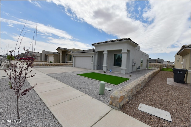 13106 Cleethorpes St, El Paso, TX 79928 - mediterranean / spanish-style house featuring stucco siding, a garage, a tile roof, concrete driveway, and a residential view