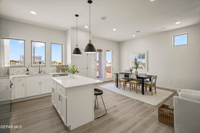14932 Hill Ridge Ct, El Paso, TX 79938 - kitchen with a sink, decorative backsplash, a kitchen island, white cabinets, and recessed lighting