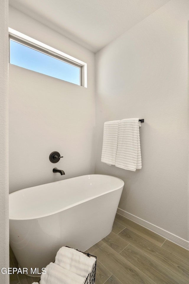 14932 Hill Ridge Ct, El Paso, TX 79938 - bathroom featuring a soaking tub, wood finished floors, and baseboards