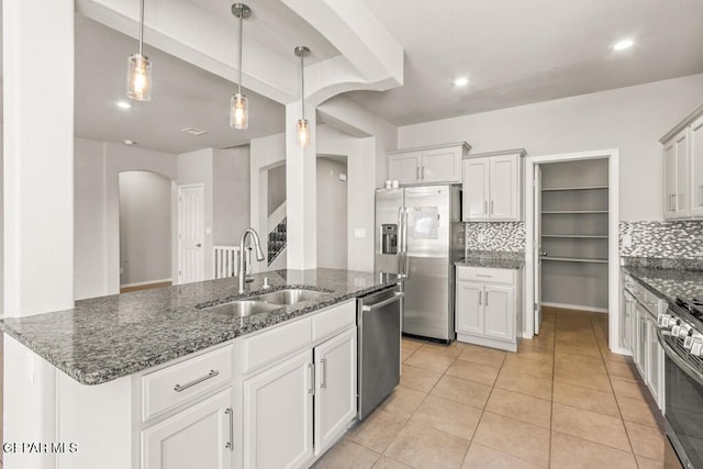 14270 Don Johnson, El Paso, TX 79938 - kitchen with appliances with stainless steel finishes, arched walkways, a sink, backsplash, and dark stone counters