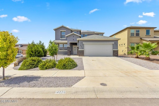 14270 Don Johnson, El Paso, TX 79938 - view of front facade with a garage, stucco siding, stone siding, and driveway