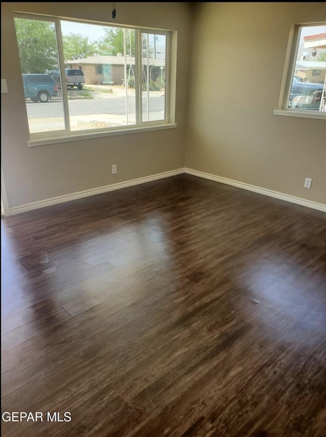 4943 Aiken Ln, El Paso, TX 79924 - empty room featuring healthy amount of natural light, dark wood-style floors, and baseboards