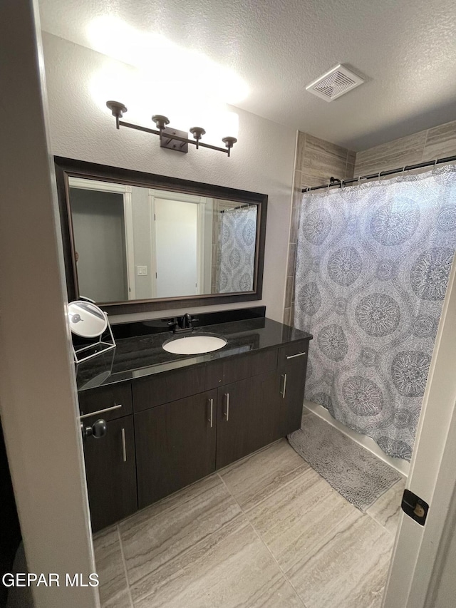 13689 Bradford St, El Paso, TX 79928 - bathroom with vanity, a textured ceiling, and curtained shower