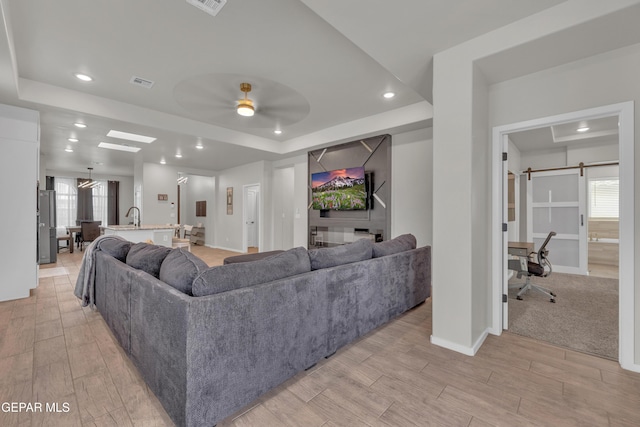 281 Farnborough St, Horizon City, TX 79928 - living area featuring a raised ceiling, baseboards, light wood-type flooring, ceiling fan, and recessed lighting