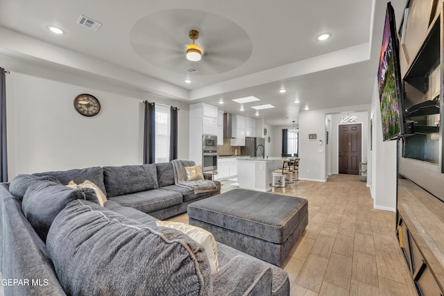 281 Farnborough St, Horizon City, TX 79928 - living area with light wood-type flooring, ceiling fan, healthy amount of natural light, a tray ceiling, and recessed lighting