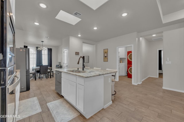 281 Farnborough St, Horizon City, TX 79928 - kitchen with a sink, white cabinetry, a kitchen island with sink, light stone countertops, and light wood-type flooring