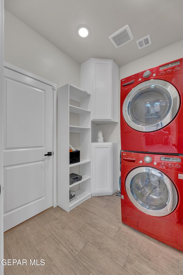 281 Farnborough St, Horizon City, TX 79928 - laundry room featuring stacked washer and clothes dryer and cabinet space