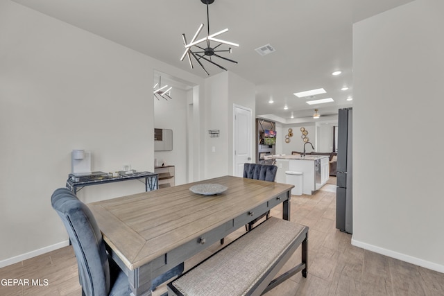 281 Farnborough St, Horizon City, TX 79928 - dining space with light wood-type flooring, a chandelier, recessed lighting, baseboards, and a skylight