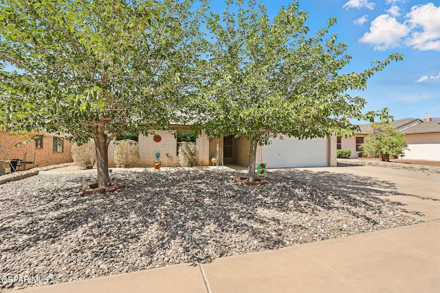 7721 Maya Ave, El Paso, TX 79912 - obstructed view of property with concrete driveway, a garage, and brick siding