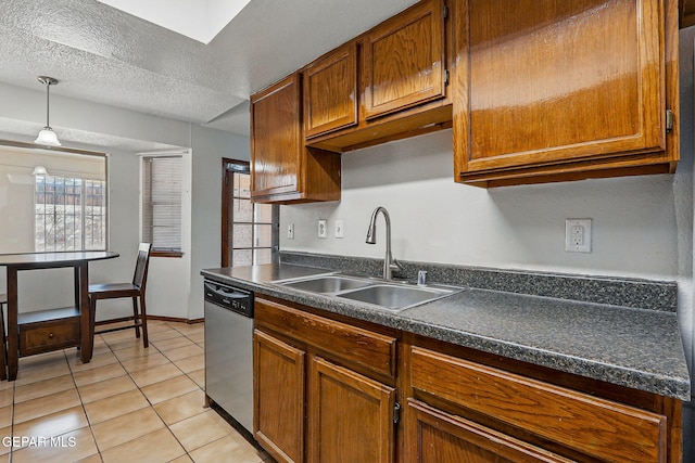7721 Maya Ave, El Paso, TX 79912 - kitchen featuring stainless steel dishwasher, a sink, dark countertops, light tile patterned floors, and a textured ceiling