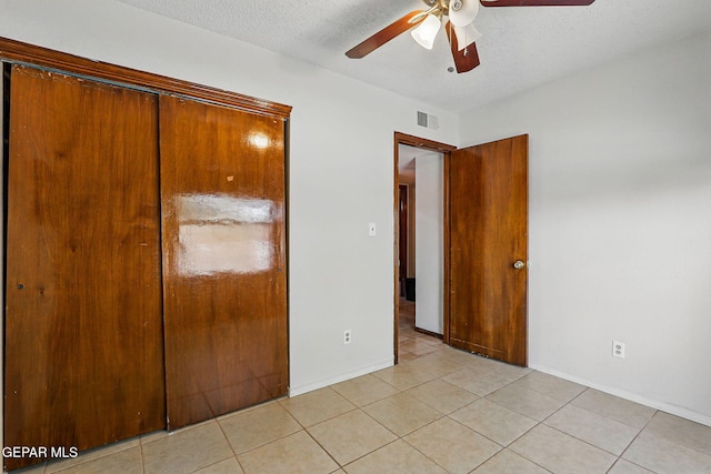 7721 Maya Ave, El Paso, TX 79912 - unfurnished bedroom with light tile patterned flooring, a textured ceiling, baseboards, and a ceiling fan