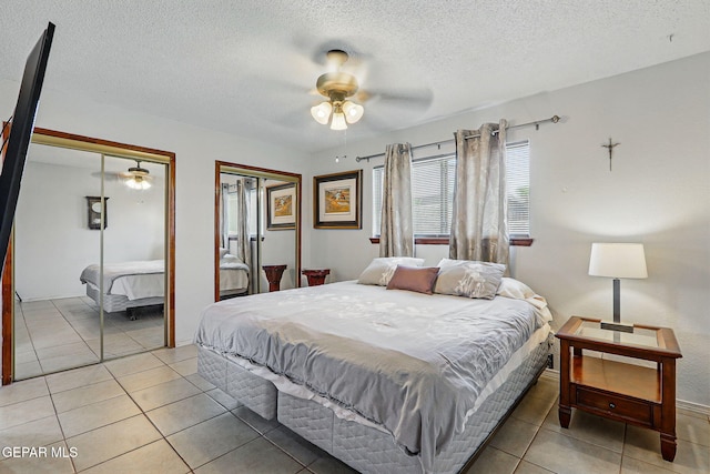 7721 Maya Ave, El Paso, TX 79912 - bedroom featuring two closets, light tile patterned floors, a textured ceiling, and ceiling fan