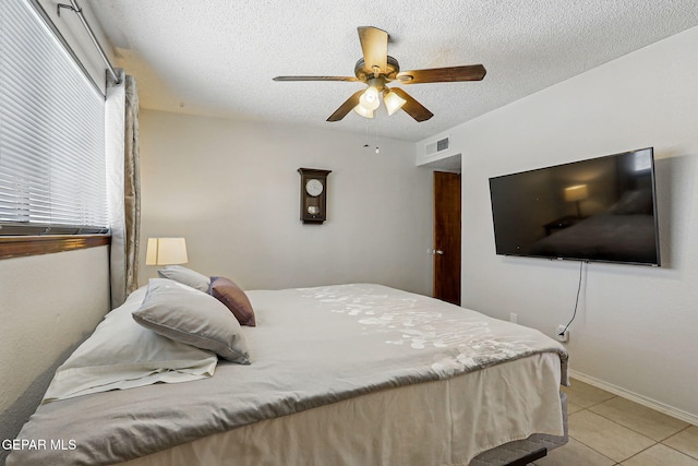 7721 Maya Ave, El Paso, TX 79912 - bedroom with light tile patterned floors, a textured ceiling, a ceiling fan, and baseboards