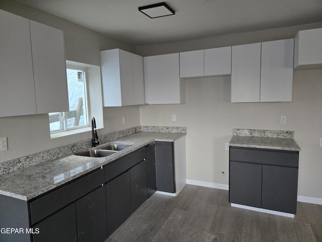 2917 Mobile Ave, El Paso, TX 79930 - kitchen with a sink, dark wood finished floors, white cabinetry, and baseboards