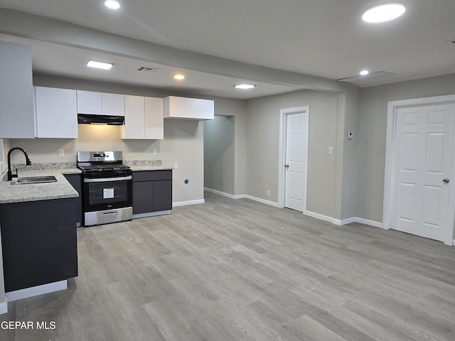 2917 Mobile Ave, El Paso, TX 79930 - kitchen featuring stainless steel gas range oven, under cabinet range hood, white cabinetry, light wood-style flooring, and recessed lighting