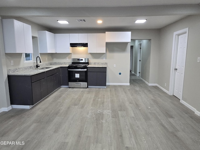 2917 Mobile Ave, El Paso, TX 79930 - kitchen featuring gas range, white cabinets, under cabinet range hood, light wood-style floors, and recessed lighting
