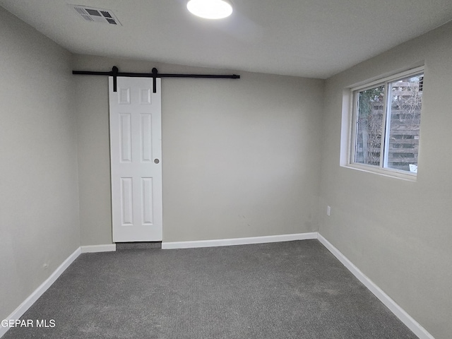 2917 Mobile Ave, El Paso, TX 79930 - unfurnished room with a barn door and dark carpet