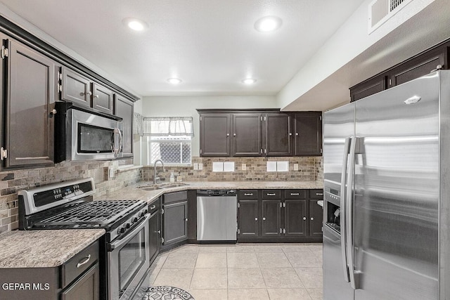 5429 Santiago Roque Dr, El Paso, TX 79934 - kitchen featuring stainless steel appliances, a sink, tasteful backsplash, light tile patterned floors, and recessed lighting