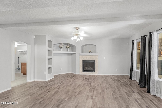 5429 Santiago Roque Dr, El Paso, TX 79934 - unfurnished living room with a ceiling fan, wood finished floors, a textured ceiling, a glass covered fireplace, and baseboards