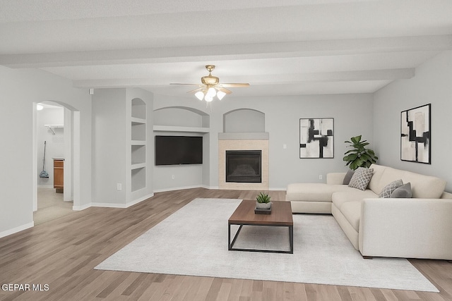 5429 Santiago Roque Dr, El Paso, TX 79934 - living room featuring beam ceiling, arched walkways, wood finished floors, a ceiling fan, and baseboards