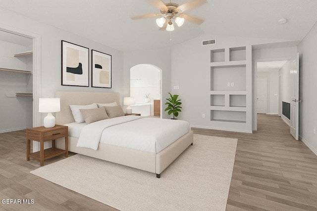 5429 Santiago Roque Dr, El Paso, TX 79934 - bedroom featuring arched walkways, light wood-style floors, baseboards, lofted ceiling, and ceiling fan