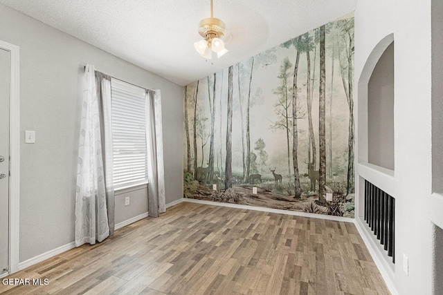5429 Santiago Roque Dr, El Paso, TX 79934 - spare room with wood finished floors, ceiling fan, arched walkways, and baseboards