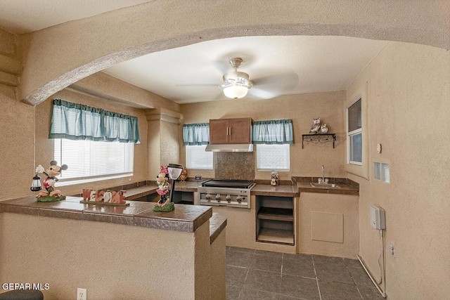 5429 Santiago Roque Dr, El Paso, TX 79934 - kitchen with under cabinet range hood, a sink, a ceiling fan, healthy amount of natural light, and a textured wall