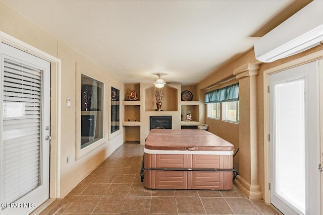 5429 Santiago Roque Dr, El Paso, TX 79934 - kitchen featuring a wall mounted air conditioner, ceiling fan, a fireplace, tile patterned flooring, and built in shelves