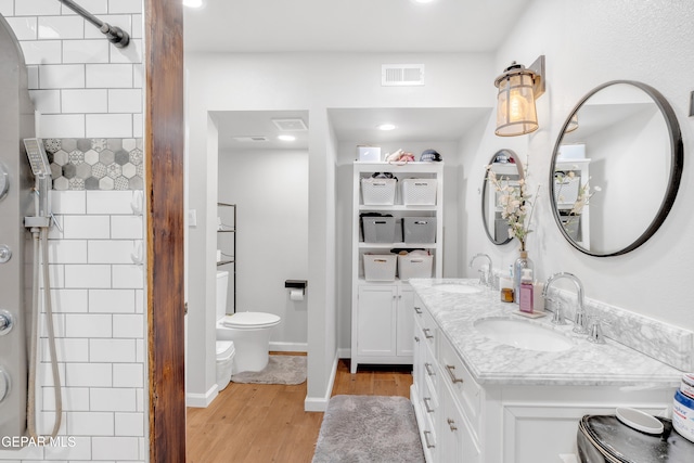 305 N Carolina Dr, El Paso, TX 79915 - full bathroom with wood finished floors, toilet, double vanity, tiled shower, and recessed lighting