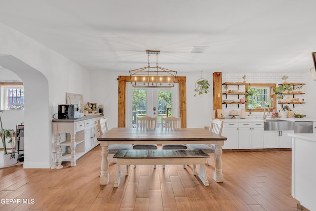 305 N Carolina Dr, El Paso, TX 79915 - dining space with arched walkways, light wood-type flooring, and french doors
