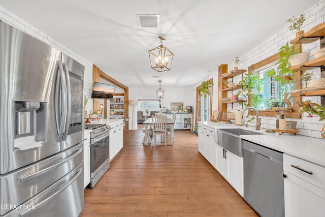305 N Carolina Dr, El Paso, TX 79915 - kitchen featuring stainless steel appliances, open shelves, a chandelier, a sink, and light countertops