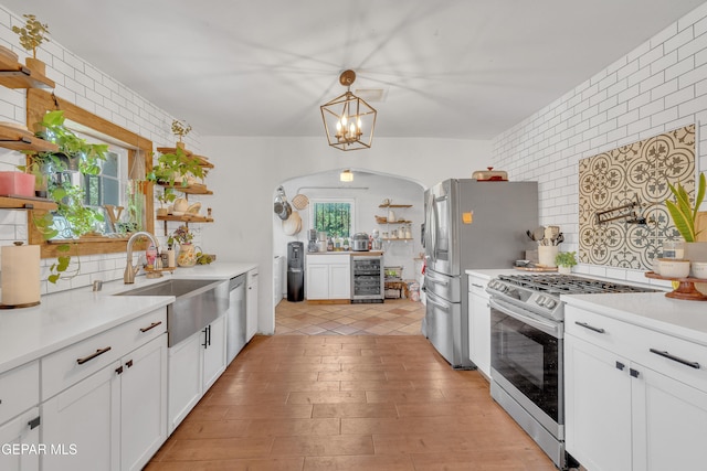 305 N Carolina Dr, El Paso, TX 79915 - kitchen with open shelves, appliances with stainless steel finishes, a sink, beverage cooler, and tasteful backsplash