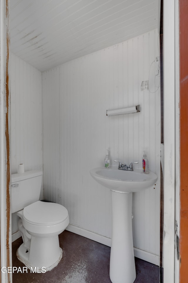 305 N Carolina Dr, El Paso, TX 79915 - half bathroom featuring toilet, finished concrete flooring, a sink, and baseboards