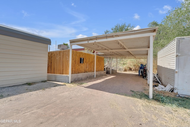305 N Carolina Dr, El Paso, TX 79915 - view of vehicle parking featuring dirt driveway and a carport
