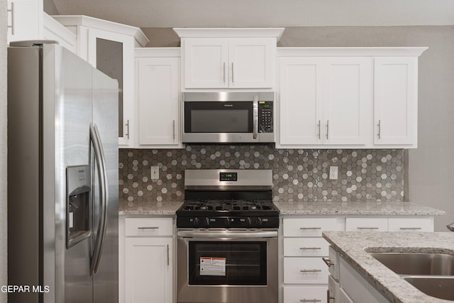 1329 Madero Ave, El Paso, TX 79928 - kitchen featuring appliances with stainless steel finishes, white cabinets, and tasteful backsplash
