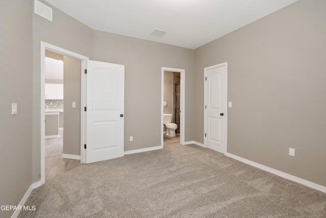 1329 Madero Ave, El Paso, TX 79928 - unfurnished bedroom with light colored carpet, ensuite bathroom, and baseboards