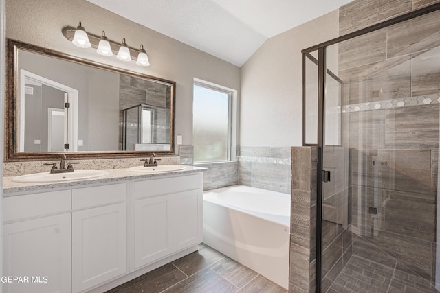 1329 Madero Ave, El Paso, TX 79928 - bathroom featuring a bath, a shower stall, double vanity, and lofted ceiling